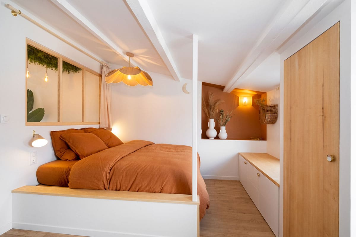 Sensation d'espace dans cette chambre avec rangements bas en blanc et bois