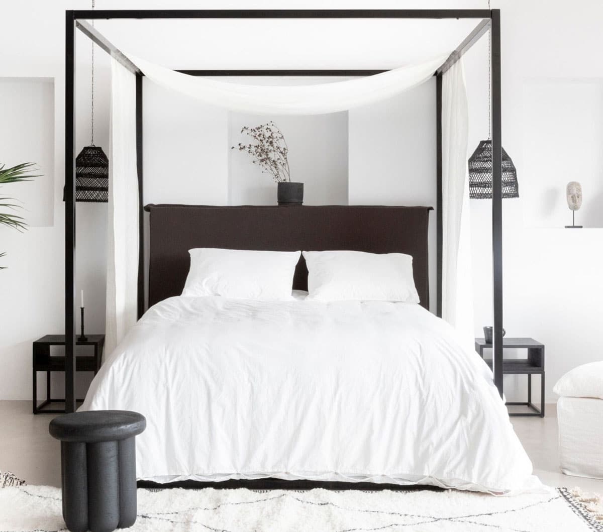 Mur blanc et mobilier noir créent l'équilibre parfait dans cette chambre au style épuré
