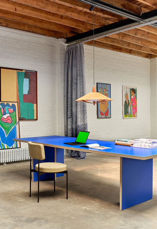 Grand bureau bleu dans un espace coloré et arty