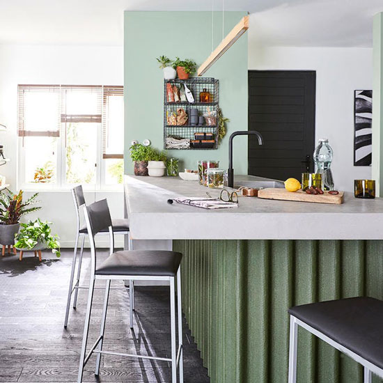 Ilot et mur vert clair dans une cuisine au style factory