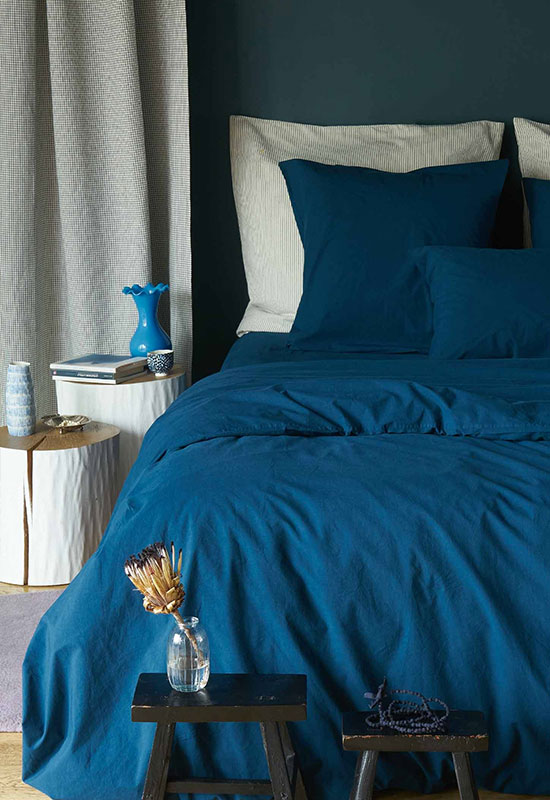 Chambre bleue avec mur bleu canard et linge de lit bleu foncé