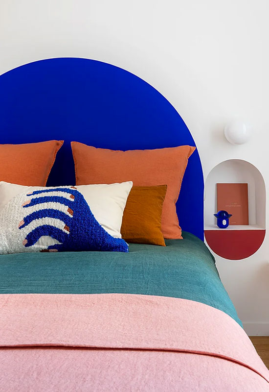 Déco colorée dans une chambre design avec tête de lit bleu électrique