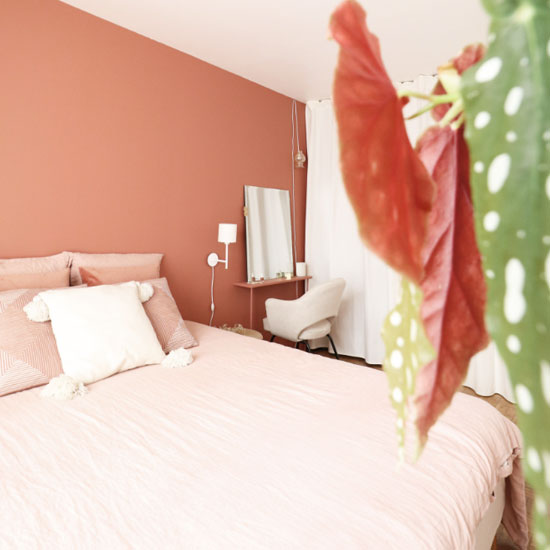 Un terracotta sur les murs s'associe à des touches plus claires de rose blush et de blanc dans cette chambre parentale
