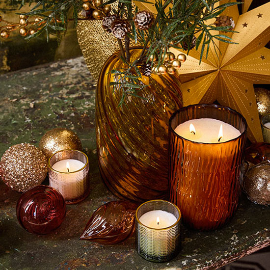 Un centre de table avec des photophores, bougies et accessoires festifs Maisons du Monde