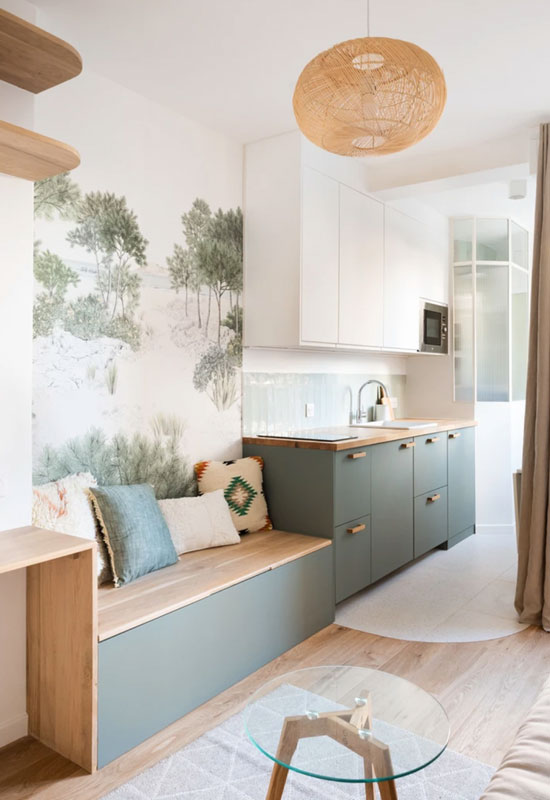 Le mur de rangement se déploie dans la cuisine, se prolonge en banquette et offre des compartiments dans l'espace séjour