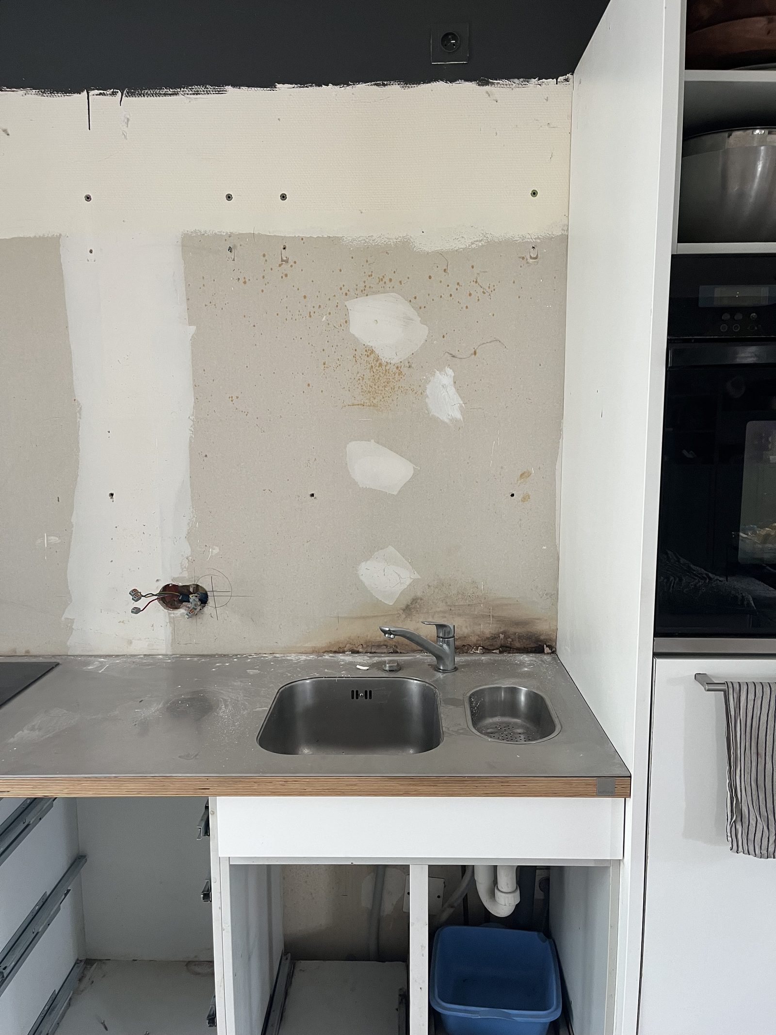 Cuisine avant rénovation : ancienne cuisine en cours de dépose avec plan de travail inox et évier d'origine