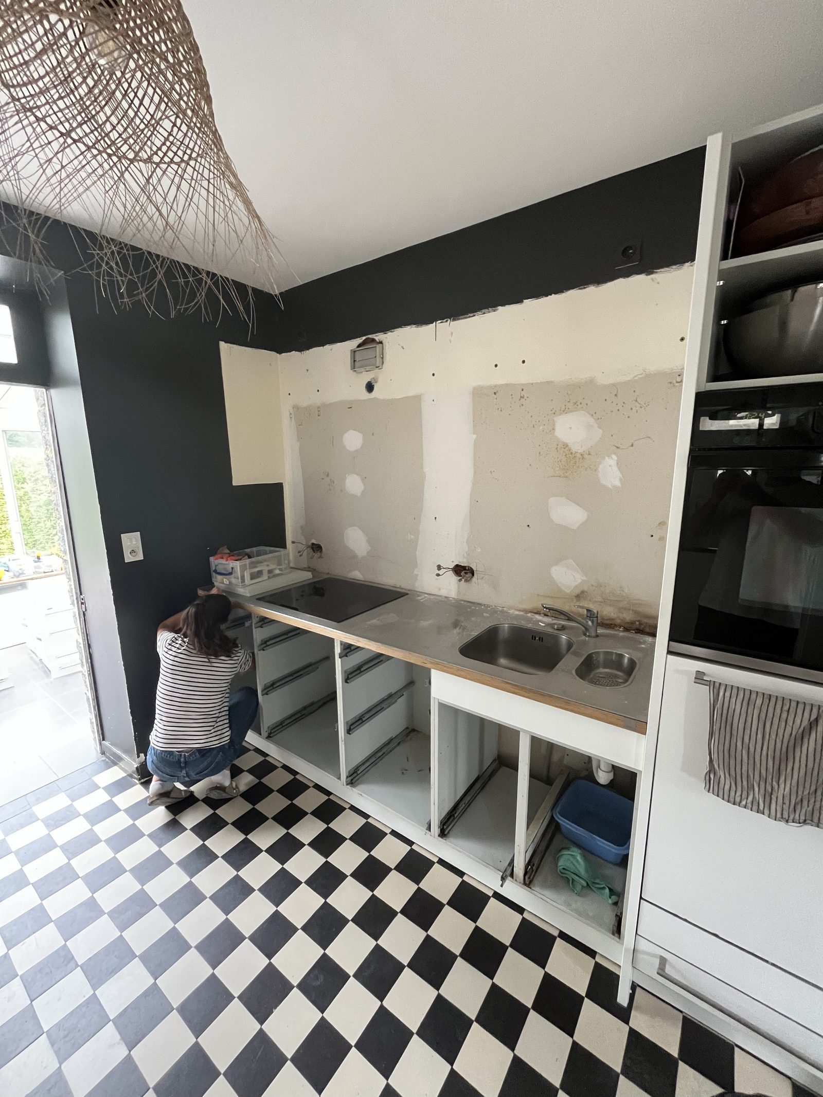 Cuisine avant rénovation : ancienne cuisine avec plan de travail inox et sol en damier noir et blanc