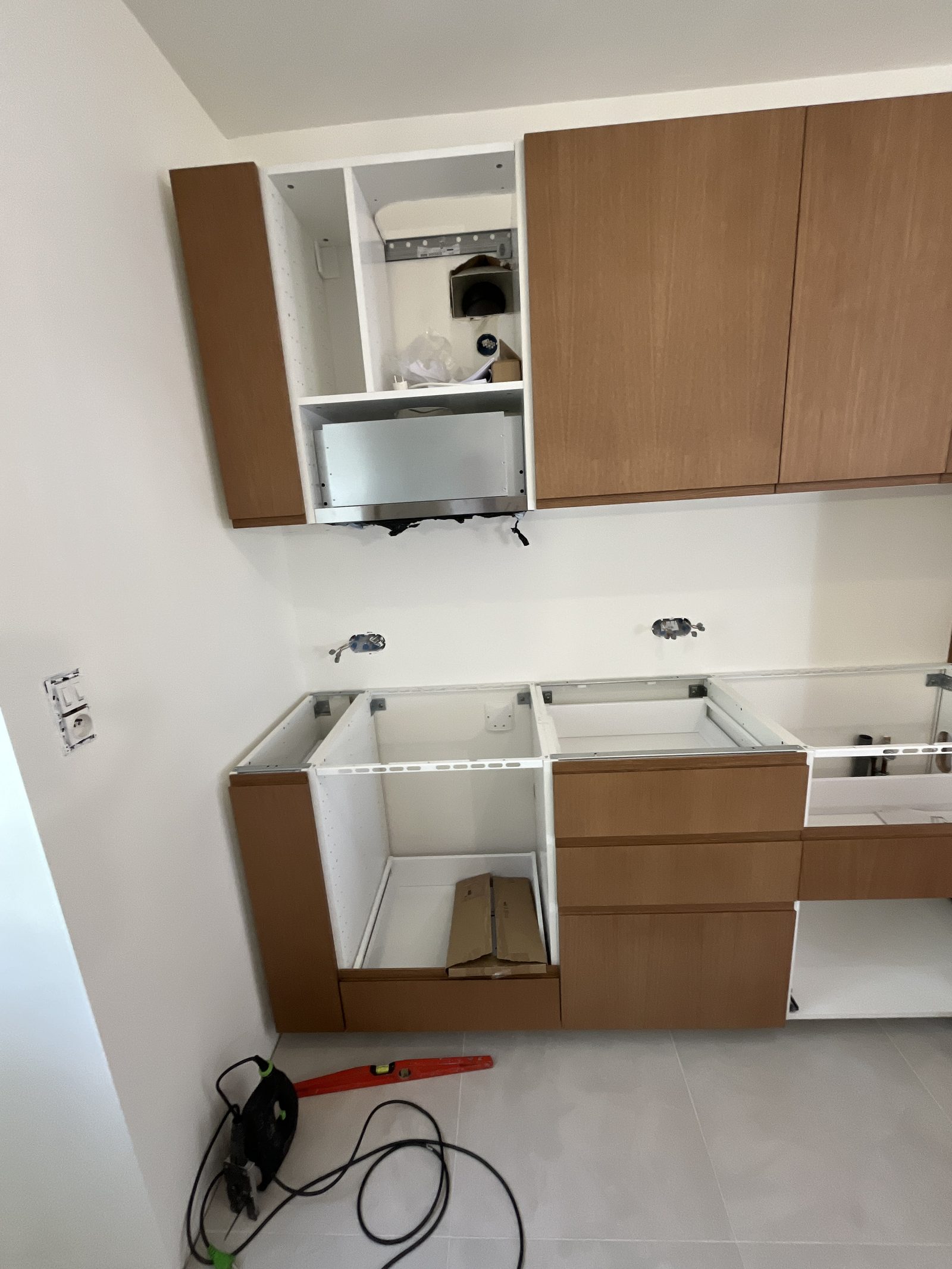 Pose des façades chêne miel Plum Living sur les caissons de la cuisine