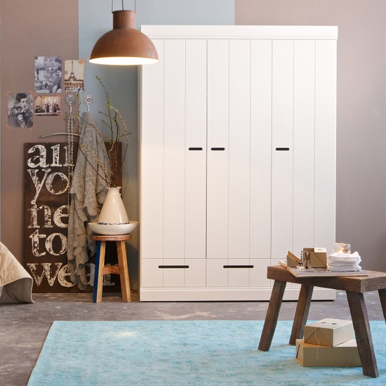 Armoire blanche Connect dans une chambre avec banc en bois et tapis bleu