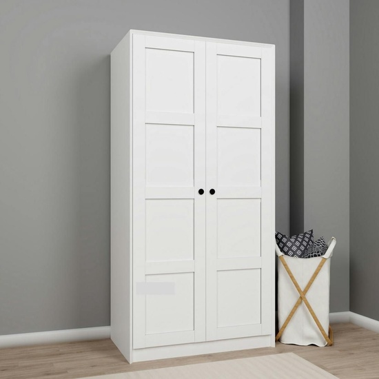 Armoire blanche Marfa contre un mur gris avec panier a linge en osier