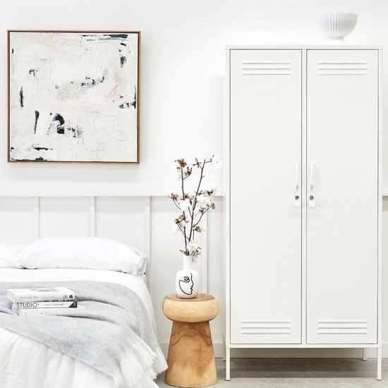 Armoire blanche en metal The Twinny dans une chambre epuree avec tabouret bois
