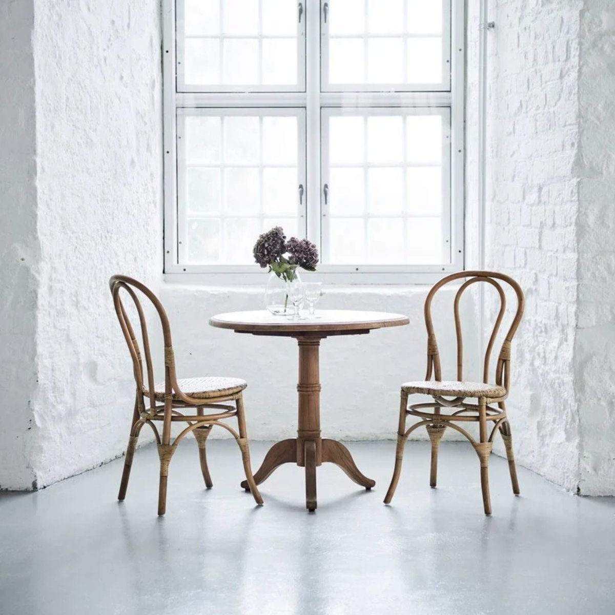 Chaises bistrot Lulu en rotin naturel autour d'un guéridon