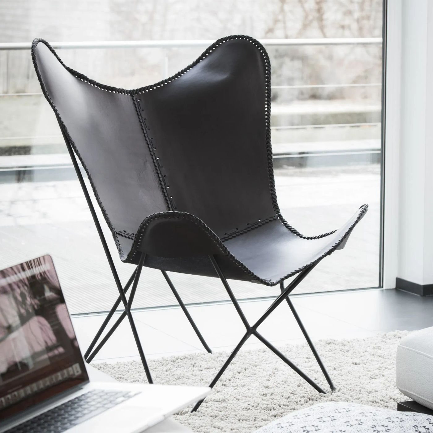 Fauteuil papillon Alto en cuir noir Hellin en ambiance