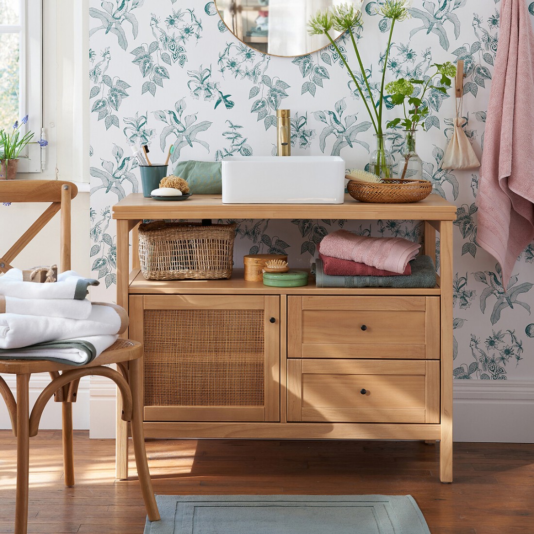 Meuble sous vasque en bois et cannage en situation dans une salle de bain