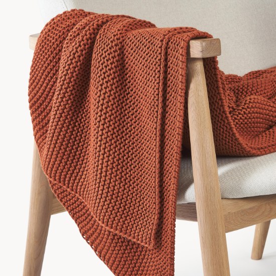 Plaid grosse maille Adalyn rouge rouille sur un fauteuil