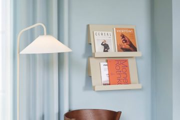 Range courrier mural en situation sur un mur bleu avec des magazines