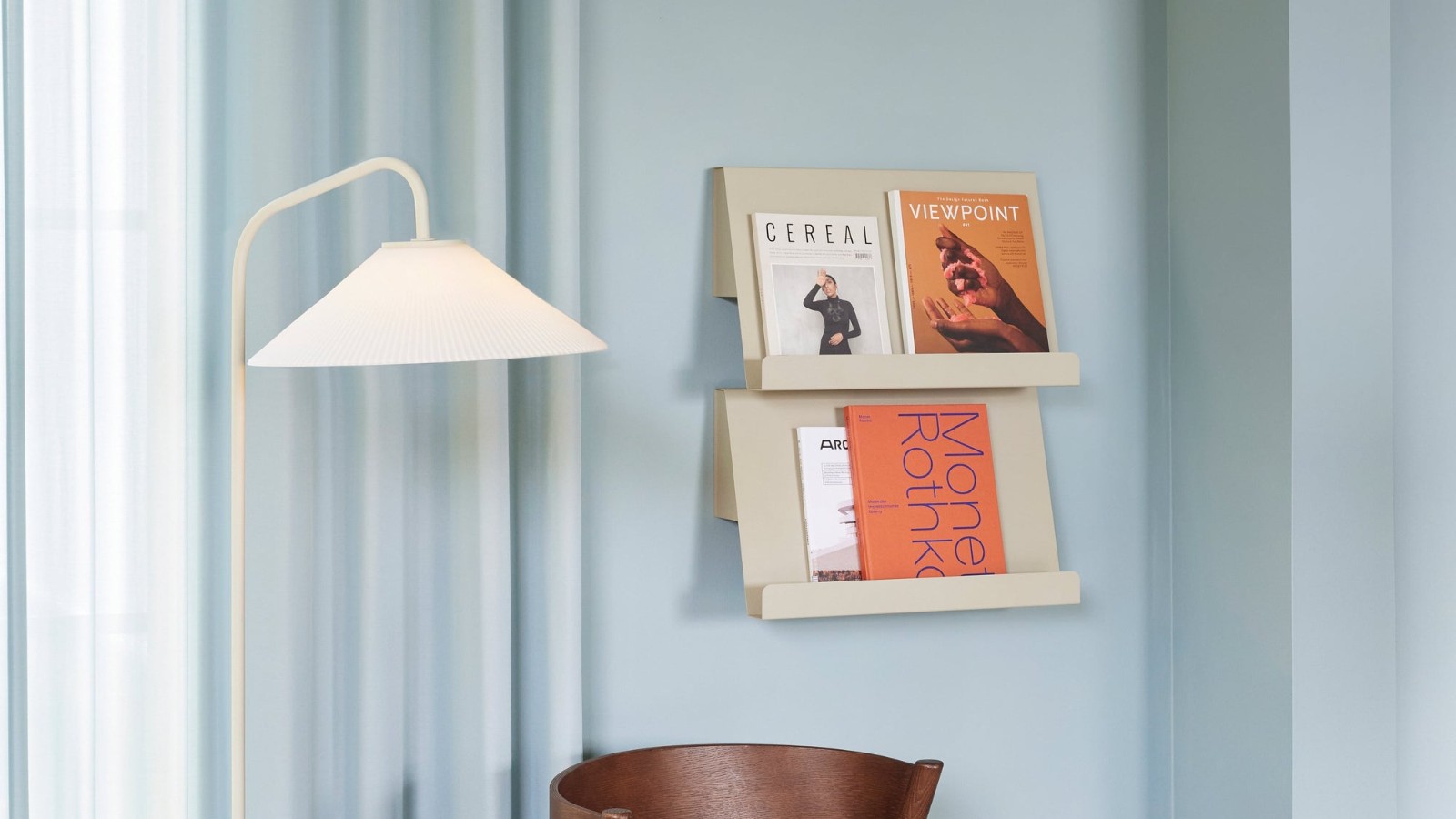 Range courrier mural en situation sur un mur bleu avec des magazines