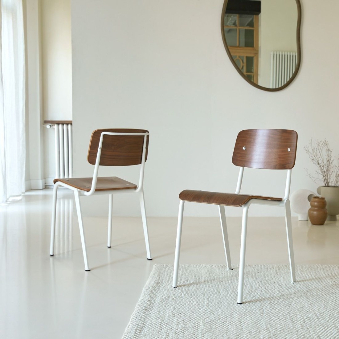 Chaises en noyer massif MIO piètement métal blanc dans un salon lumineux