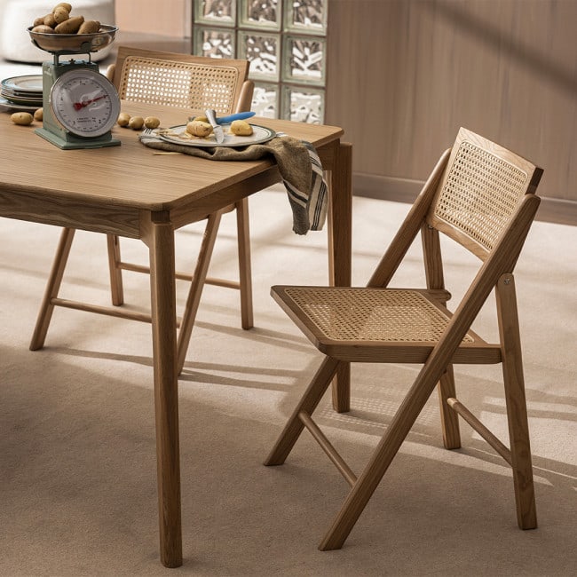 Chaise scandinave pliante Paula en cannage et bois Drawer dans une salle à manger