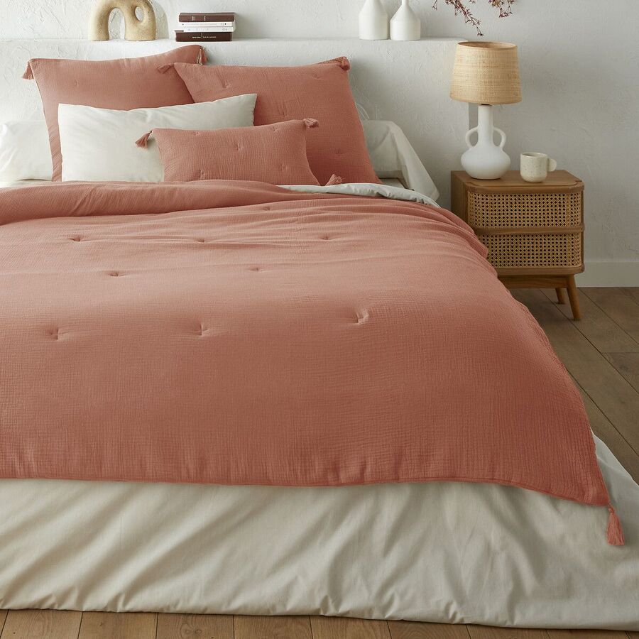 Édredon Kumla en gaze de coton terracotta posé sur un lit