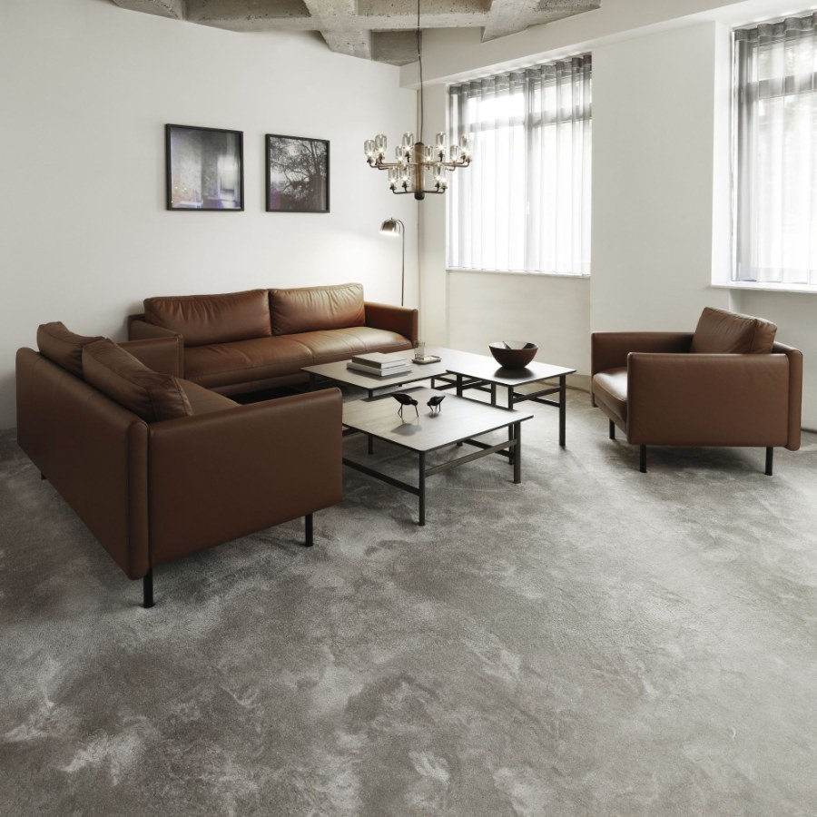 Fauteuil design Rar en cuir cognac dans un salon loft avec canapé assorti