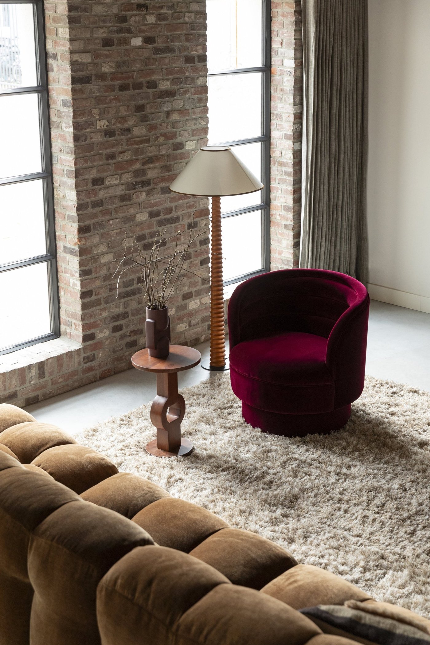 Fauteuil Dorothy pivotant en velours rouge dans un loft industriel