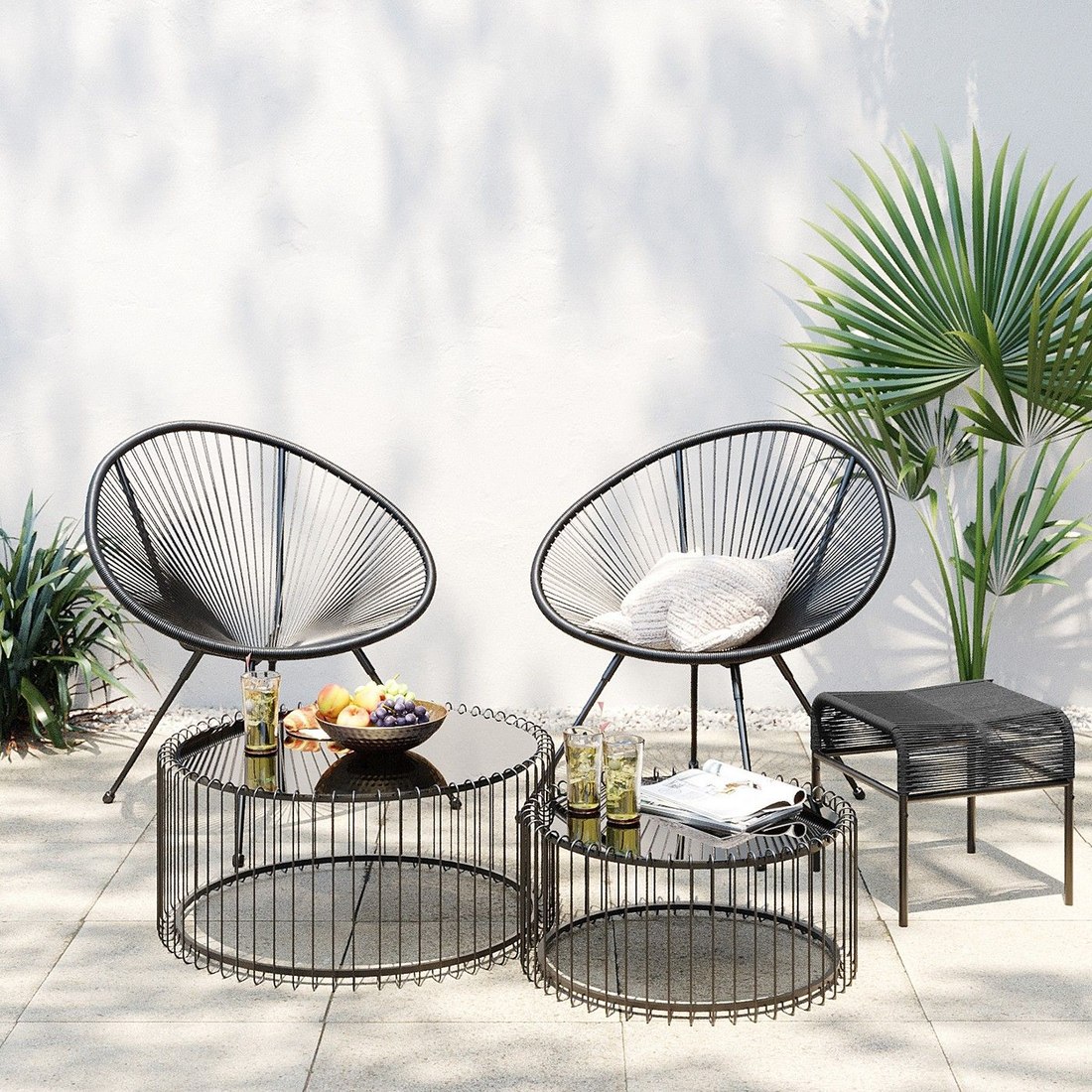 Fauteuils de jardin design Acapulco noirs installés sur une terrasse avec plantes