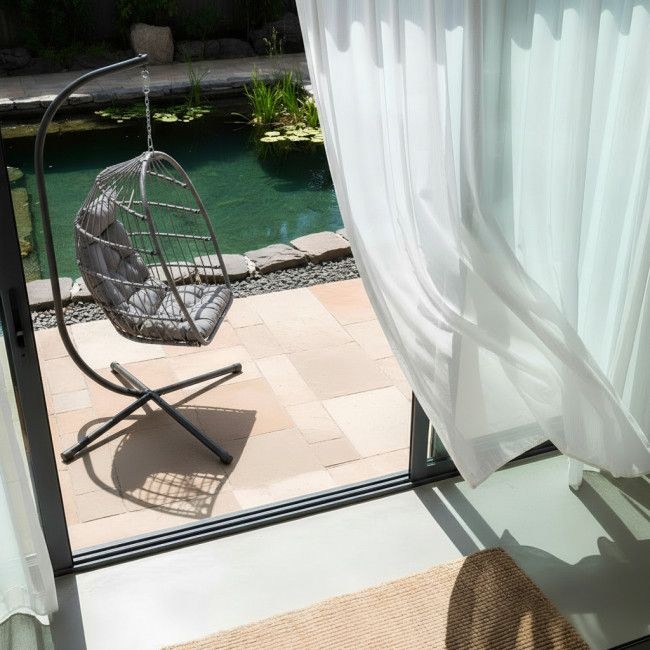 Fauteuil œuf suspendu Sully installé au bord d'une piscine, terrasse extérieure