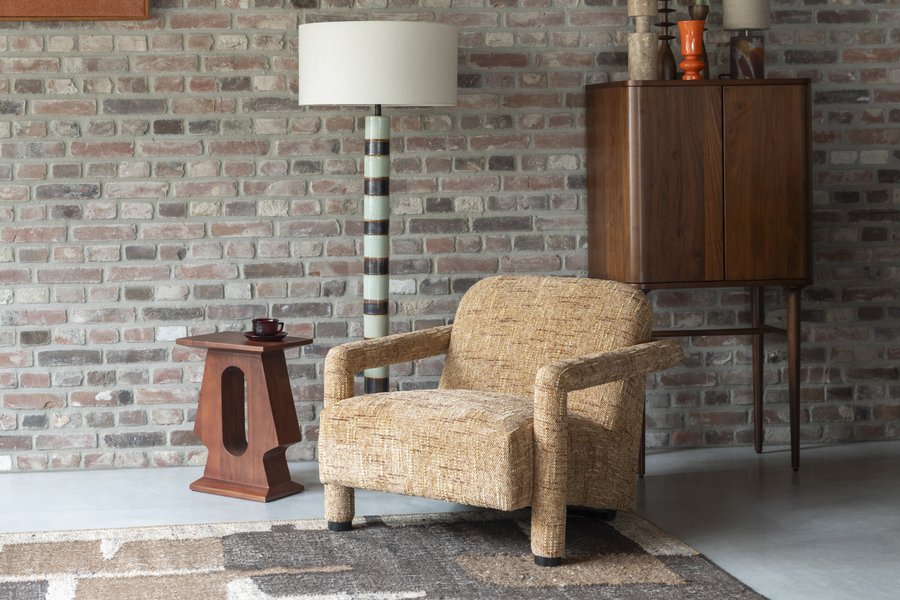 Fauteuil vintage Kent de Dutchbone en polyester ocre installé dans un salon mur de briques