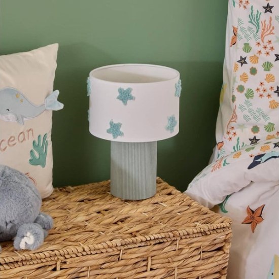 Lampe de chevet enfant étoile allumée sur une malle en osier, thème océan