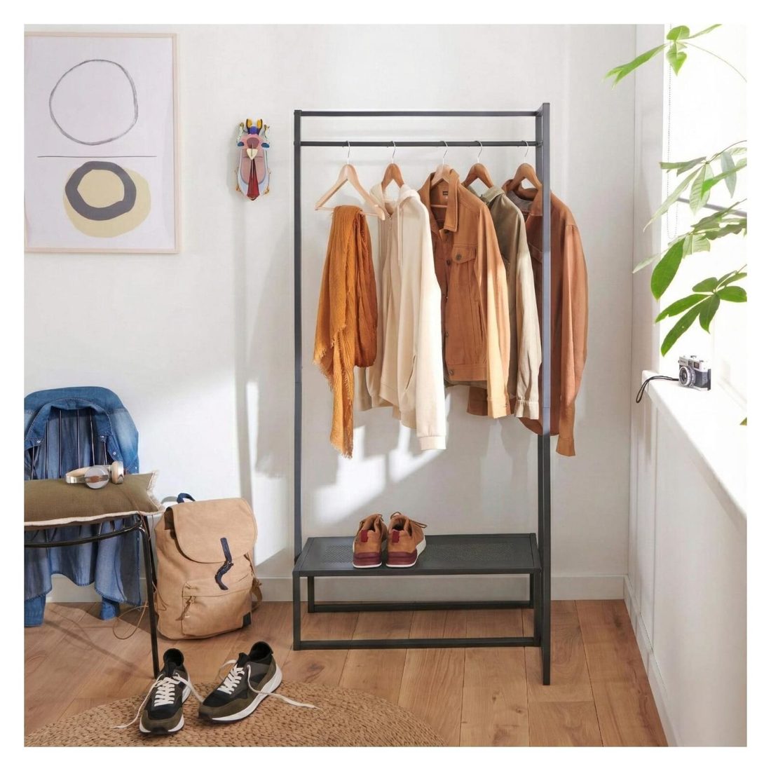 Portant à vêtements en métal noir Strada avec vêtements et chaussures dans une entrée