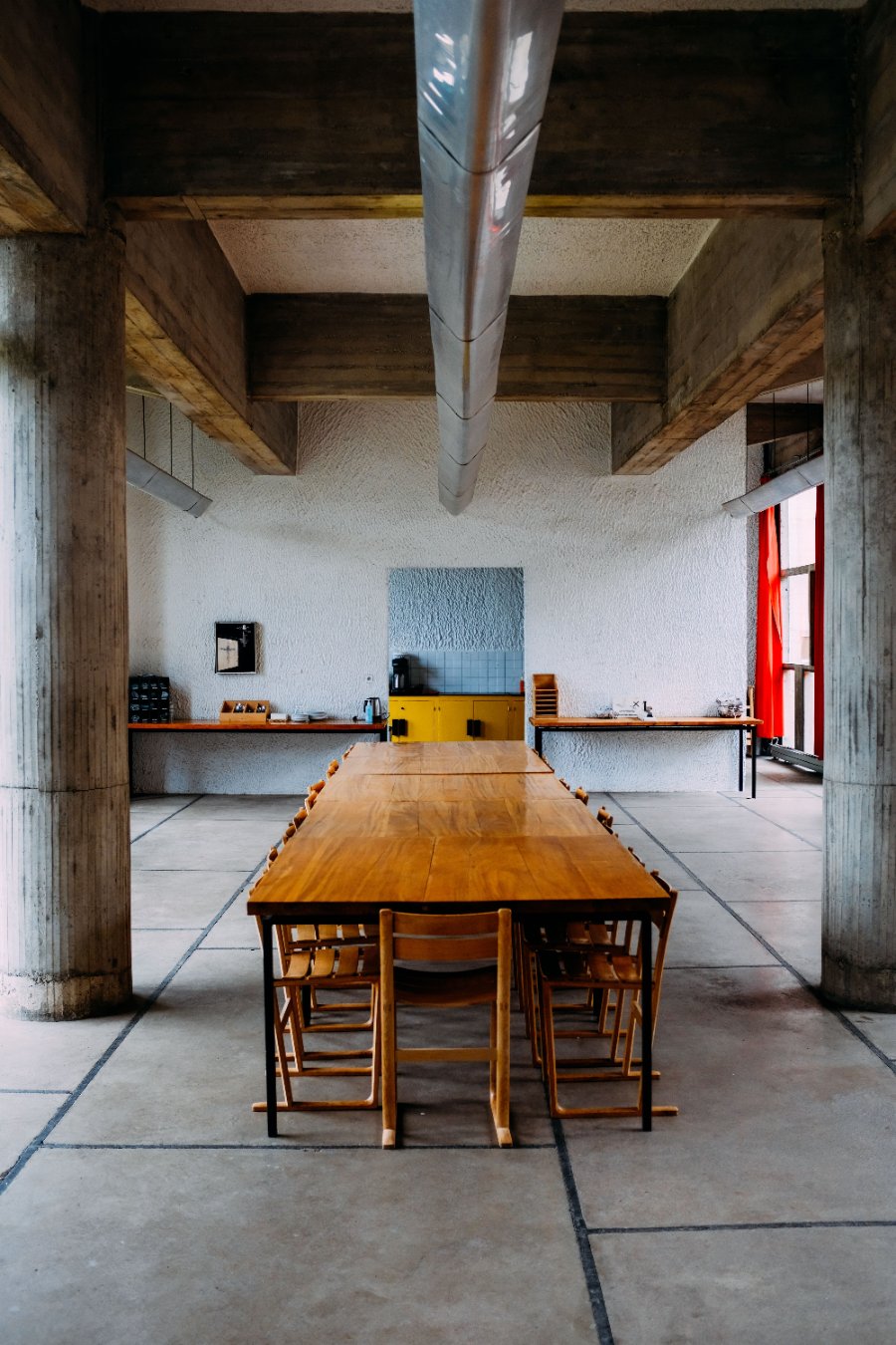 Salle à manger de style industriel avec grande table en bois massif, poutres apparentes et esprit loft