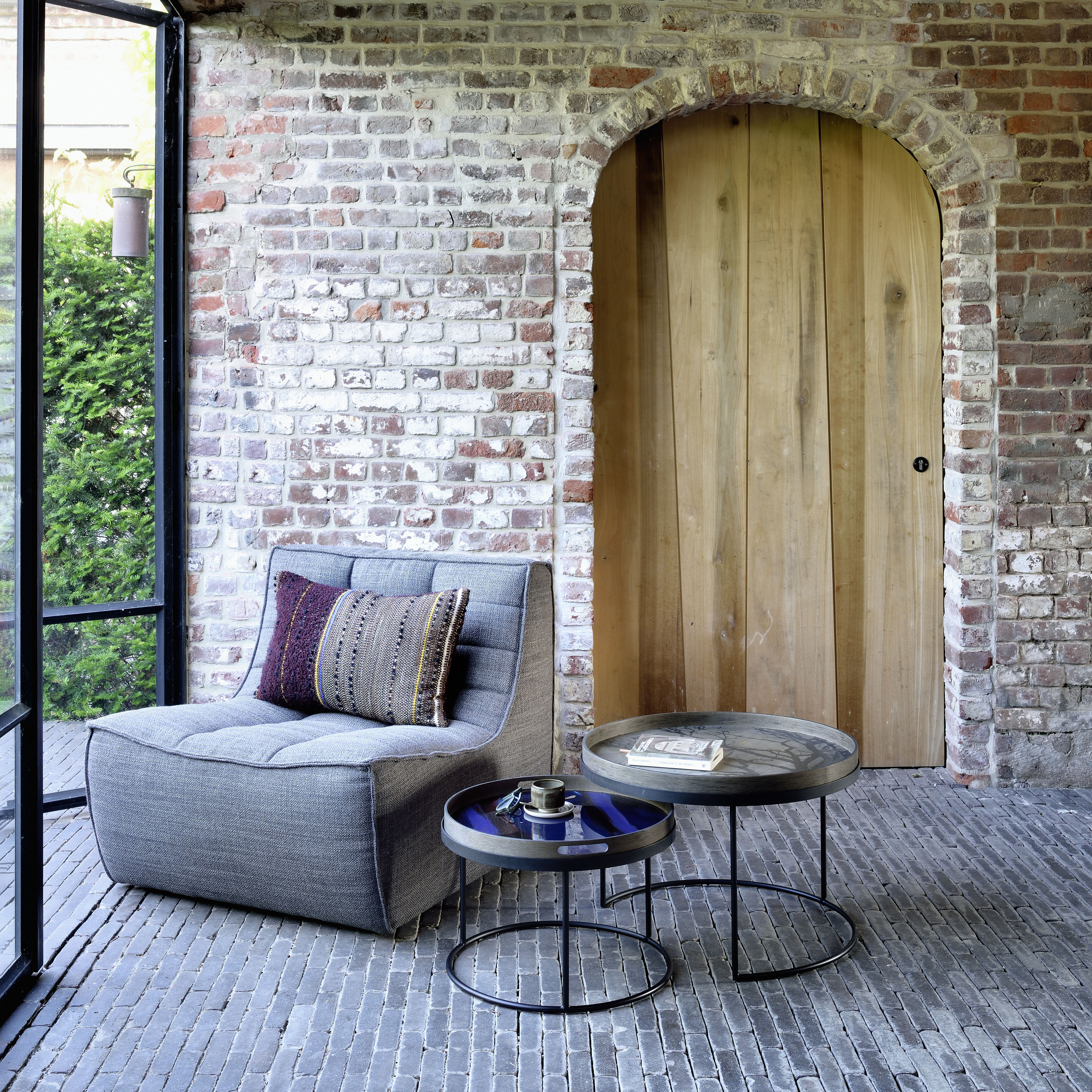 Tables basses gigognes rondes en bois noir Ethnicraft en situation dans un salon