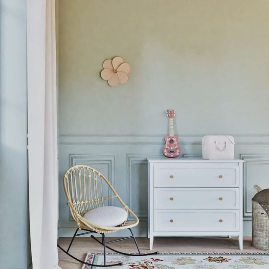 Fauteuil à bascule en rotin Maisons du Monde dans une chambre bleu pastel