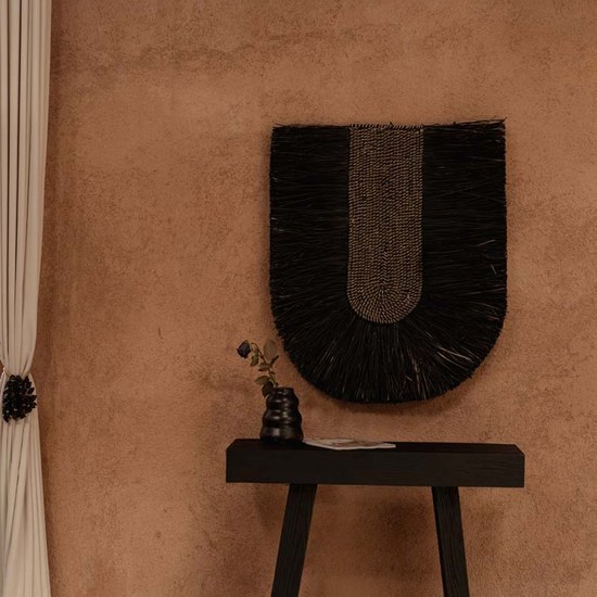 Decoration murale DADA sur un mur terracotta au dessus d un banc noir