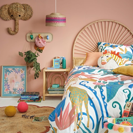 Table de chevet enfant Malga en rotin dans une chambre rose coloree