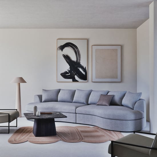 Tapis Kersa de forme organique Maisons du Monde sous une table basse devant un canapé bleu gris