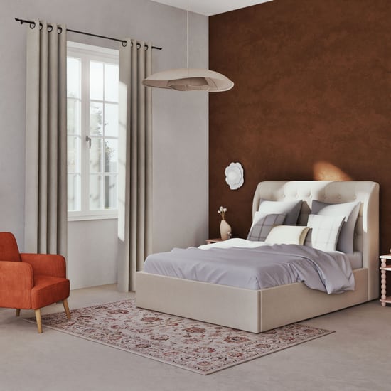 Tapis oriental Nasera Maisons du Monde au pied d'un lit dans une chambre aux tons terracotta